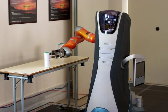A Care-O-Bot service robot picks up an object from a table